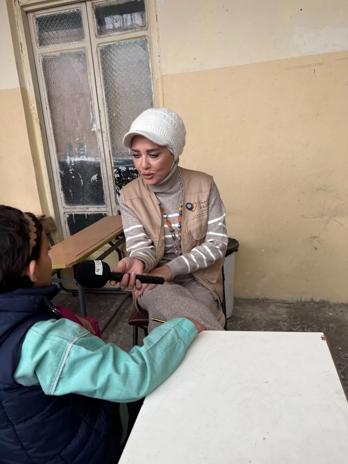 عضو من فريق حياة واحدة يستمع إلى طالب في مدرسته