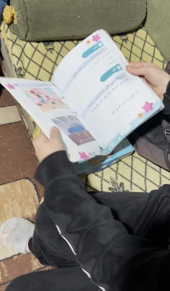 طفل يقرأ في كتابه المدرسي في المنزل